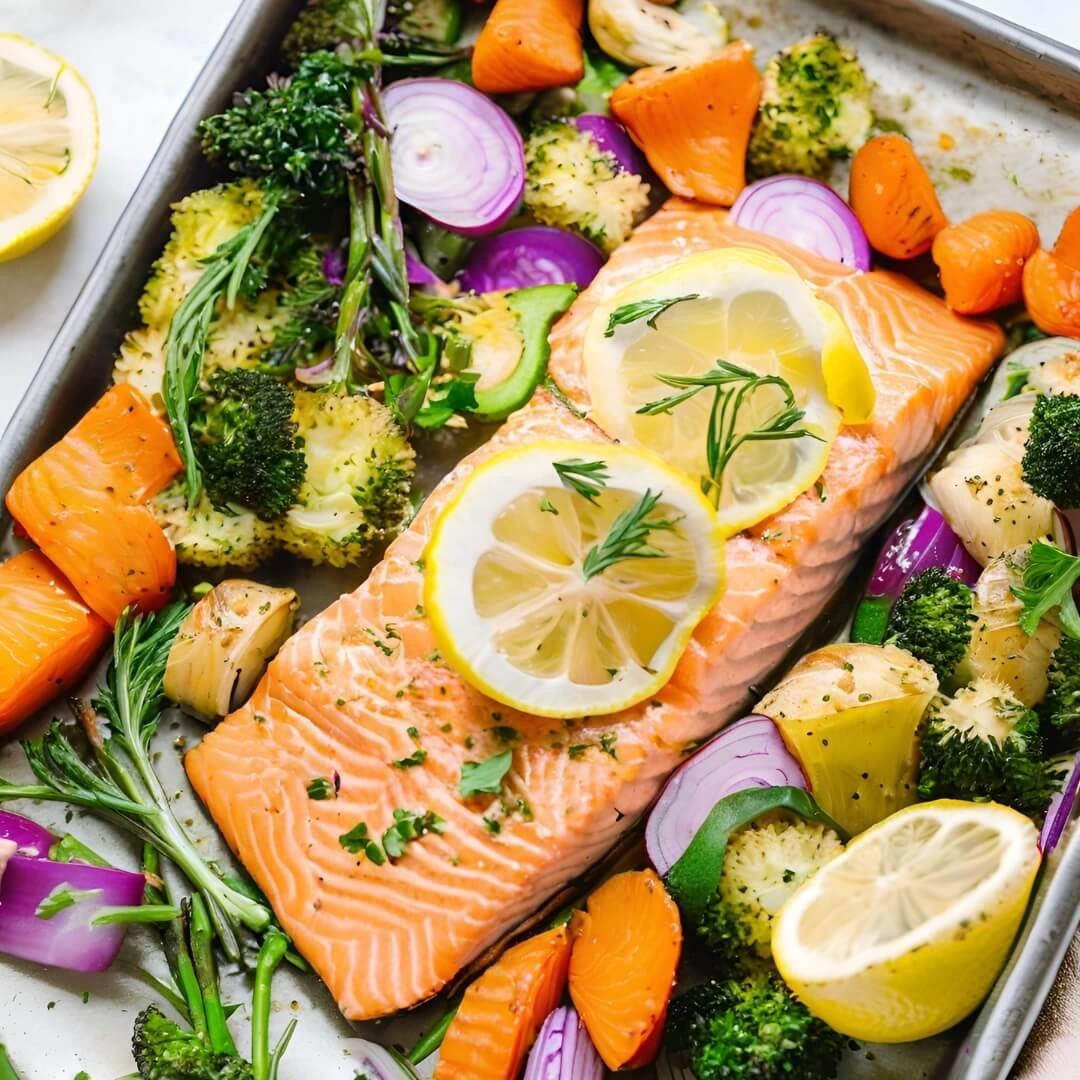 A sheet pan filled with Lemon Herb Salmon & Veggies, featuring perfectly cooked salmon fillets glazed with a zesty lemon-herb mixture, surrounded by roasted asparagus, cherry tomatoes, and potatoes, all golden and aromatic.